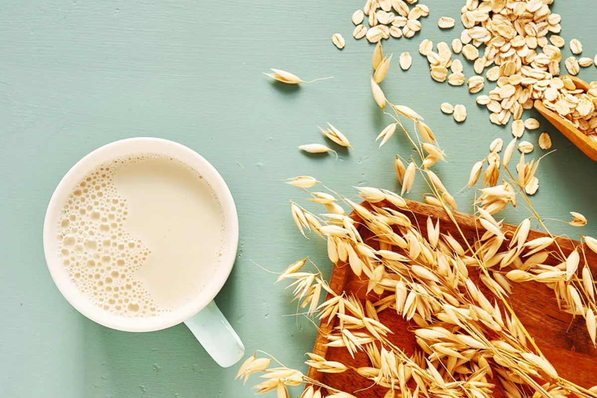 Glass of low-fat milk next to plant-based oat milk – best choices for milk and cholesterol management – Hamza The Dietitian