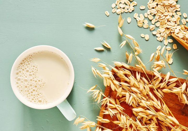 Glass of low-fat milk next to plant-based oat milk – best choices for milk and cholesterol management – Hamza The Dietitian