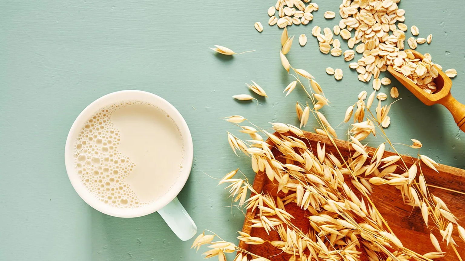 Glass of low-fat milk next to plant-based oat milk – best choices for milk and cholesterol management – Hamza The Dietitian